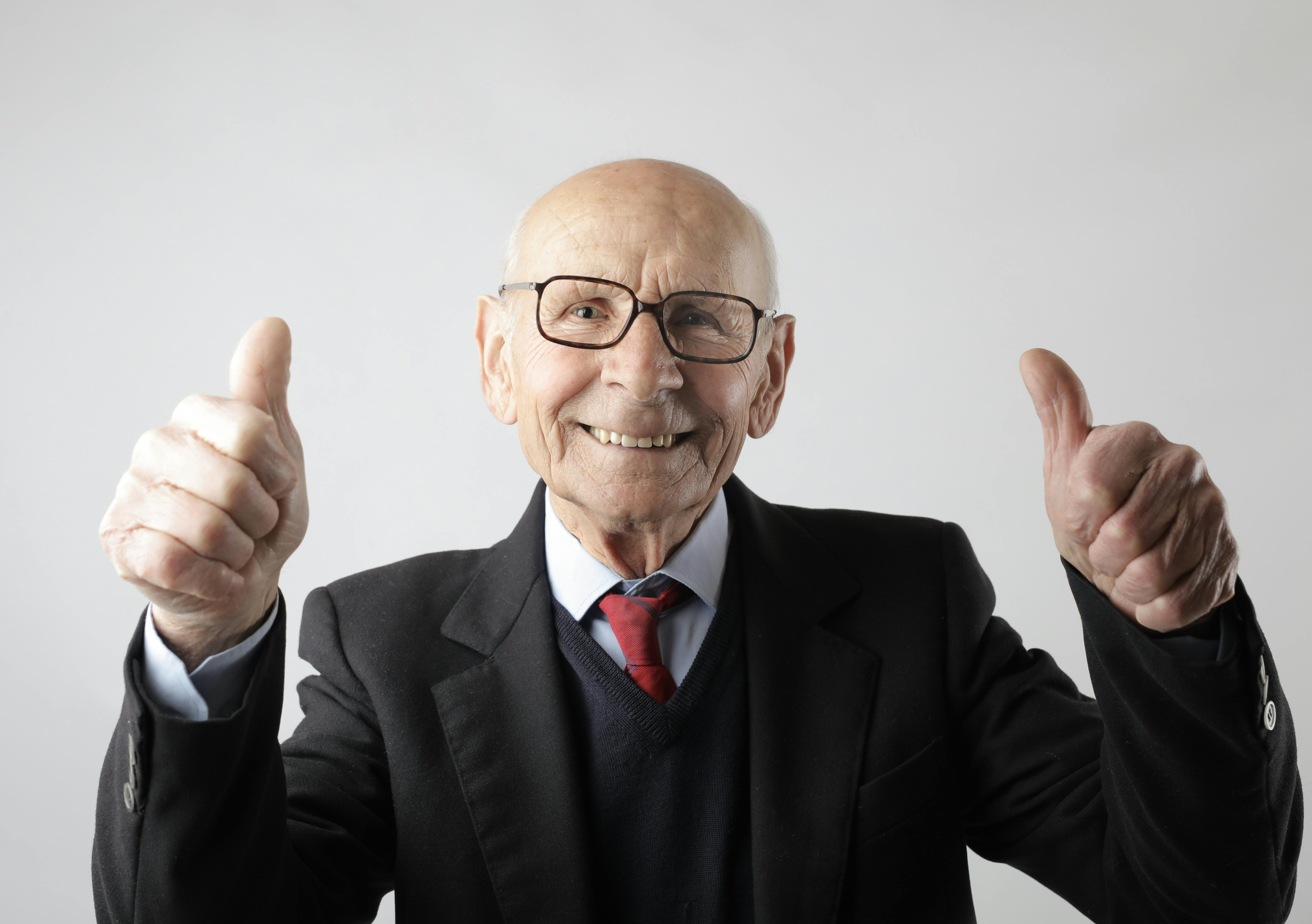 Positive senior man in eyeglasses showing thumbs up and looking at camera by Andrea Piacquadio on Pexels